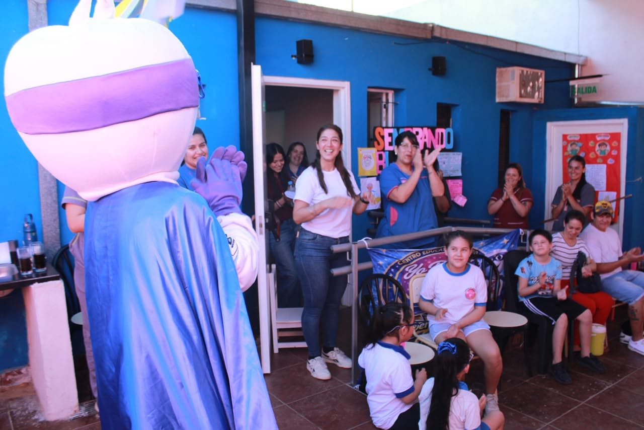 La mascota de Yo Puedo saludando a niños y al equipo