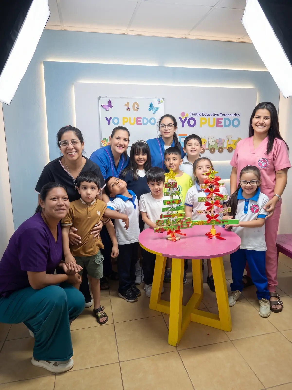 Grupo armando un árbol de Navidad artesanal por los 10 años de Yo Puedo