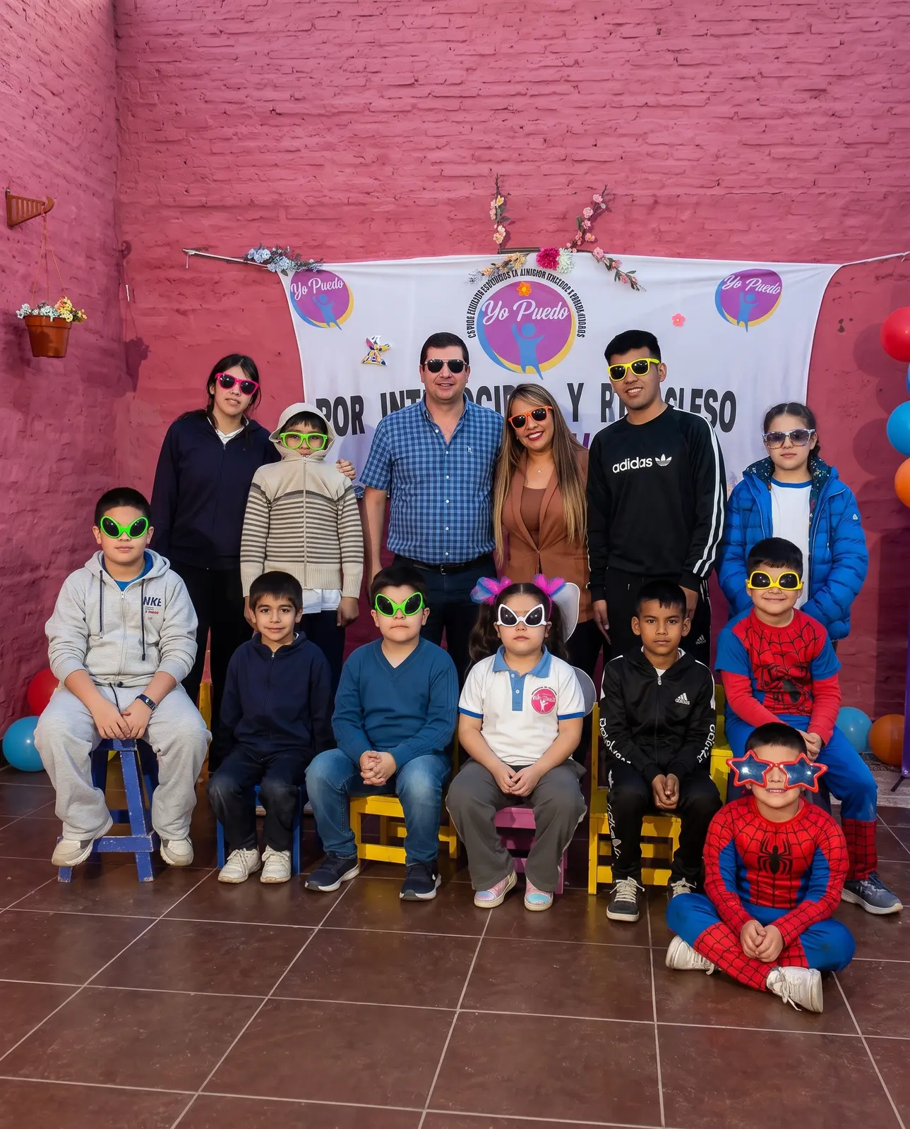 Grupo grande festejando con anteojos de disfraz en Yo Puedo